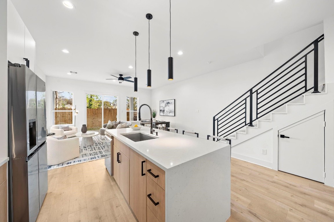 309 East 43rd Street Houston, TX 77022 - Photo 6 of 17 a kitchen with sink stove and white cabinets with wooden floor