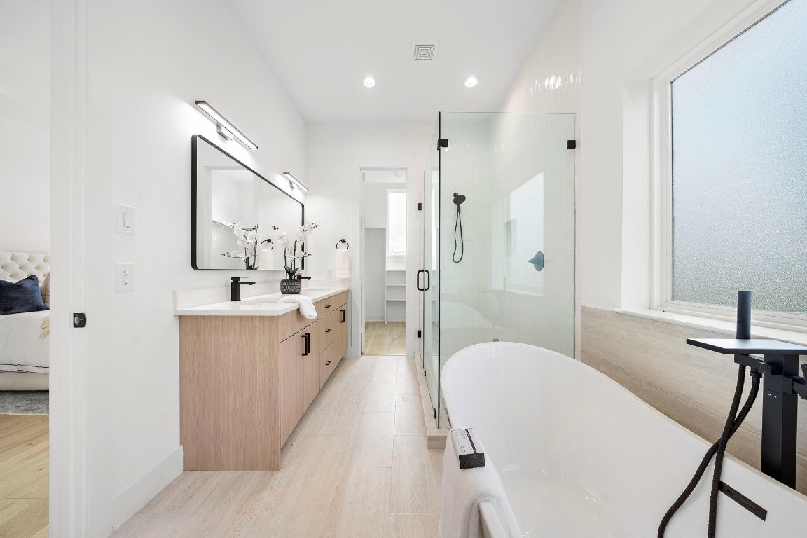 309 East 43rd Street Houston, TX 77022 - Photo 10 of 17 a spacious bathroom with a double vanity sink a mirror a bathtub and shower