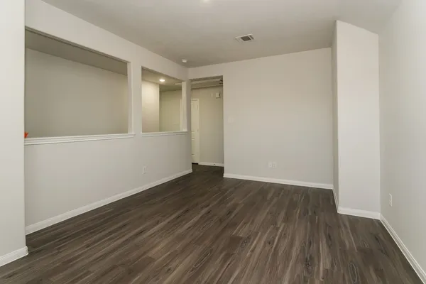 a view of an empty room with wooden floor