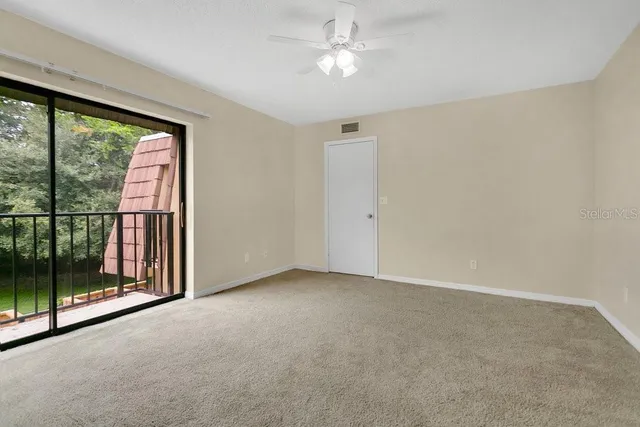 a view of a big room with windows and chandelier fan