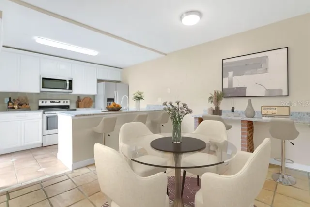 a kitchen with stainless steel appliances kitchen island granite countertop a table and chairs