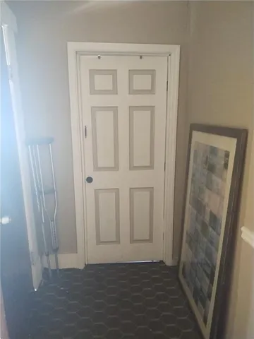 a view of a hallway with wooden floor and a living room