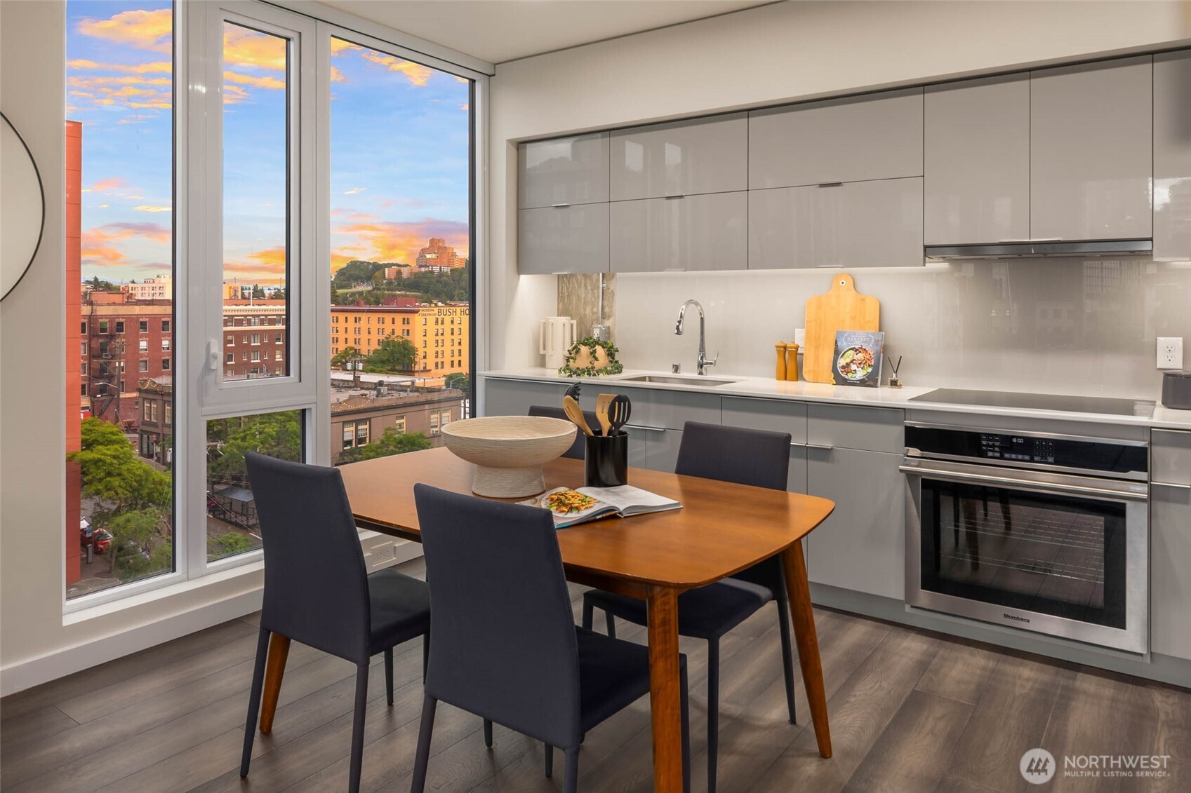 450 South Main Street, Unit 901 Seattle, WA 98104 - Photo 6 of 36 a kitchen with stainless steel appliances a stove a table and chairs