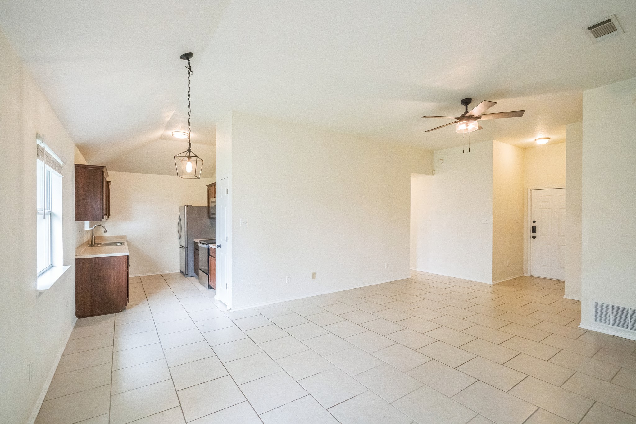 224 Amber Lane Jarrell, TX 76537 - Photo 11 of 16 Unfurnished living room featuring lofted ceiling, ceiling fan, and light tile patterned floors