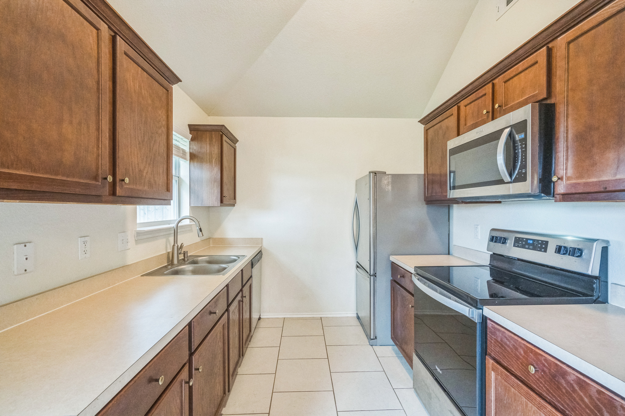 224 Amber Lane Jarrell, TX 76537 - Photo 6 of 16 Kitchen with stainless steel appliances, light countertops, and vaulted ceiling