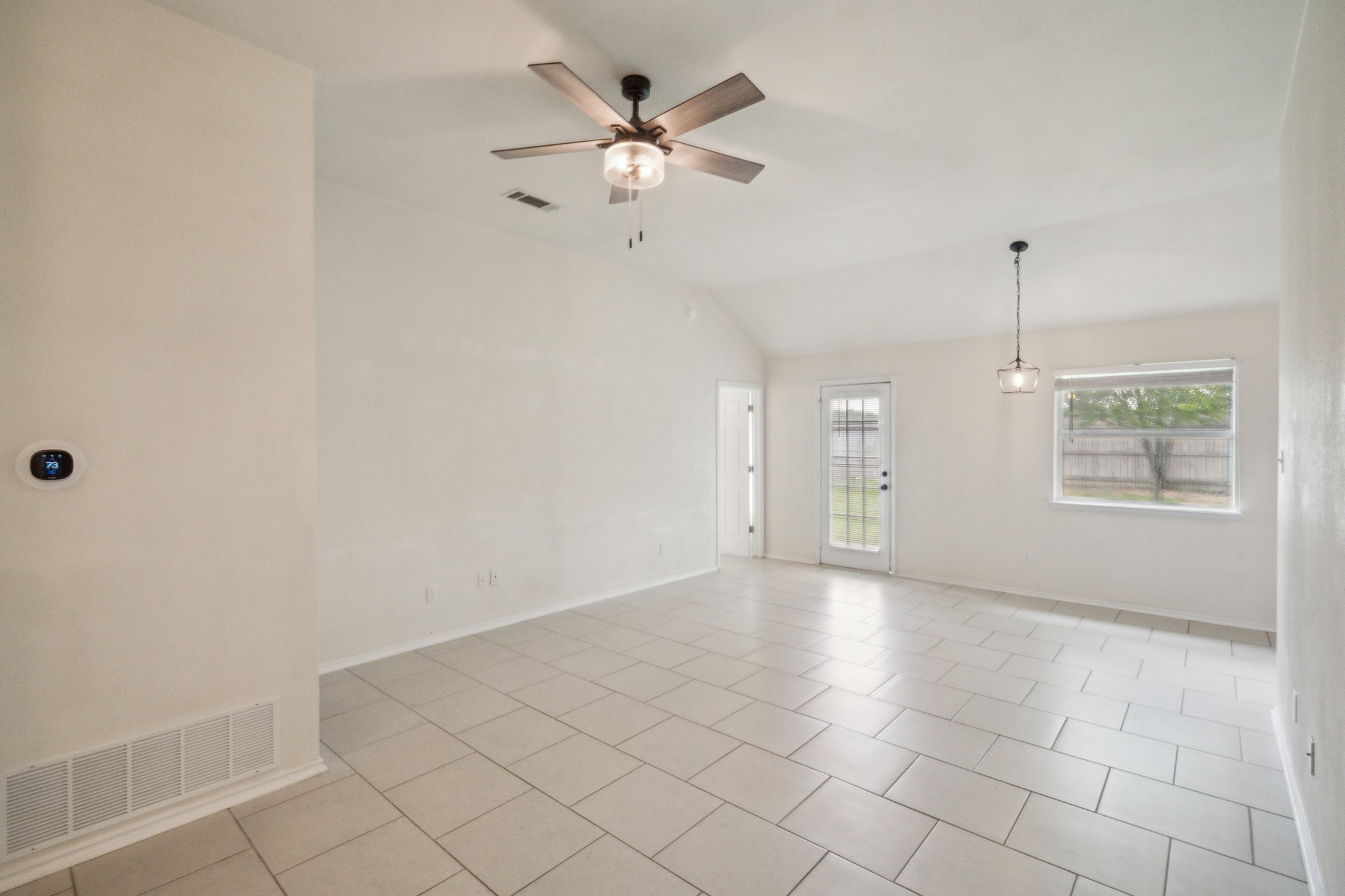 224 Amber Lane Jarrell, TX 76537 - Photo 9 of 16 Empty room featuring vaulted ceiling, a ceiling fan, and light tile patterned floors