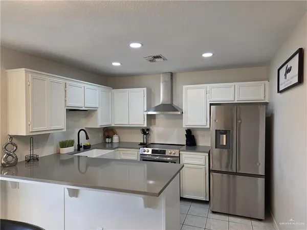a kitchen with a refrigerator sink and cabinets