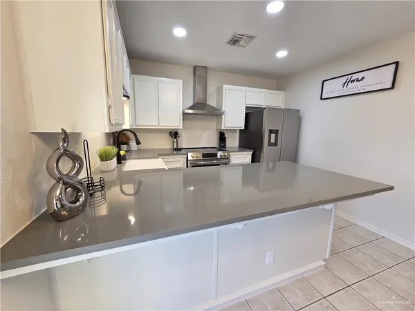 a kitchen with stainless steel appliances granite countertop a sink a stove and a refrigerator