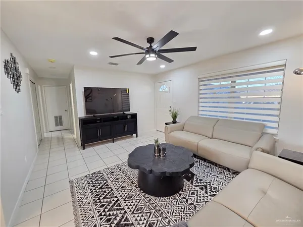 a living room with furniture a flat screen tv and a window
