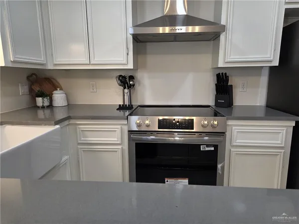 a kitchen with granite countertop white cabinets and stainless steel appliances