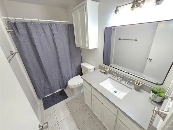 a bathroom with a sink a toilet a mirror and shower