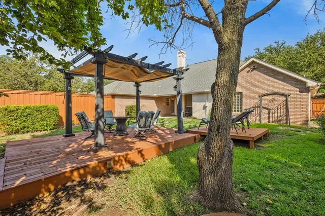 a view of a patio with table and chairs potted plants with wooden floor and fence