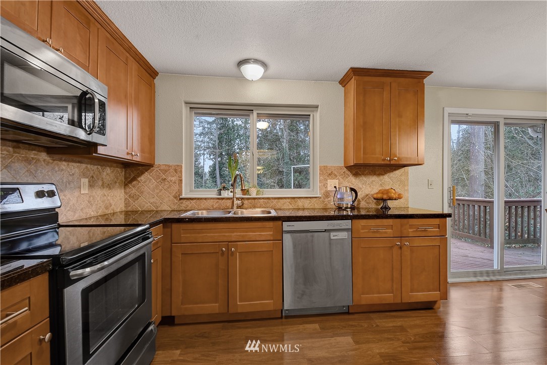 1104 204th Place Southeast Bothell, WA 98012 - Photo 3 of 22 a kitchen with stainless steel appliances granite countertop a sink stove and microwave