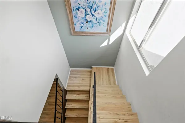 a view of staircase with lots of frames on wall and a window