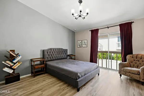 a bedroom with a large bed and a chandelier