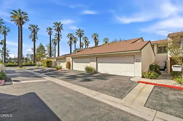 a view of a house with a yard and palm trees