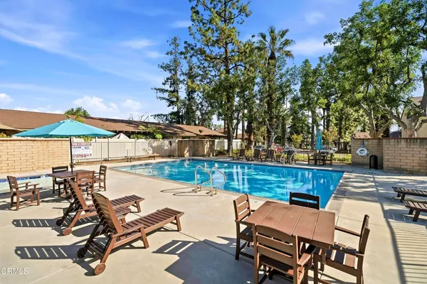 a view of a swimming pool with outdoor seating and plants