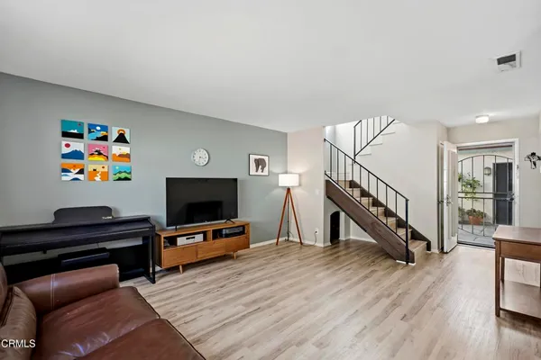 a living room with furniture and a wooden floor