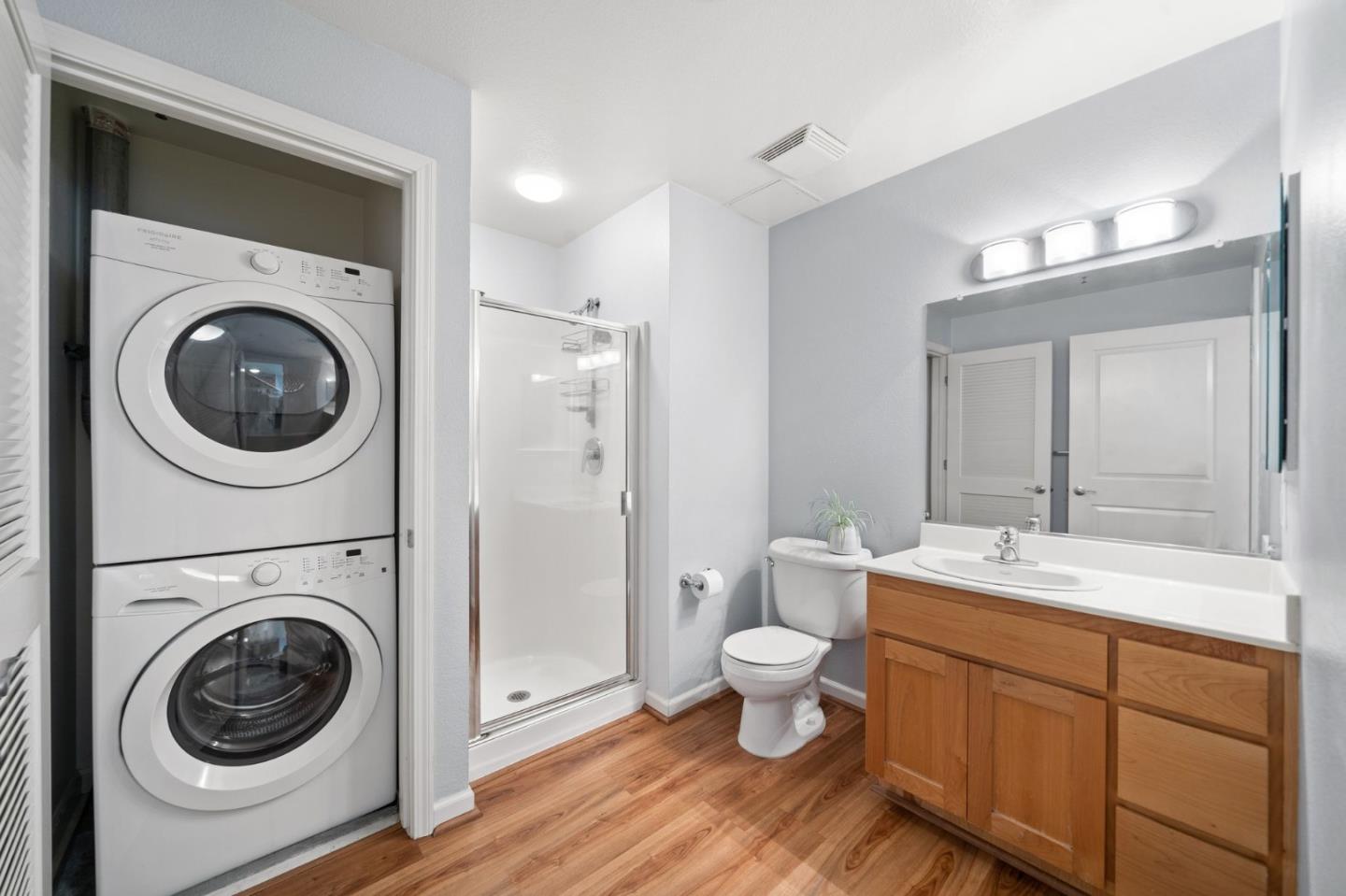 655 12th Street, Unit 312 Oakland, CA 94607 - Photo 11 of 14 a bathroom with a toilet sink and mirror