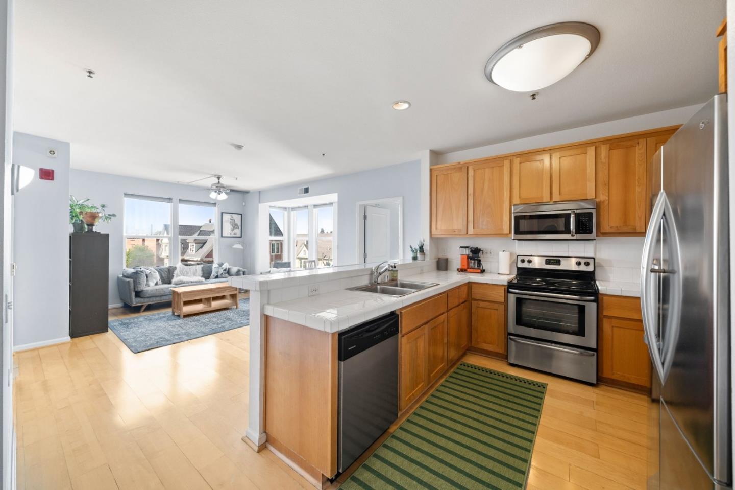 655 12th Street, Unit 312 Oakland, CA 94607 - Photo 6 of 14 a kitchen with stainless steel appliances granite countertop a lot of counter space and wooden floor