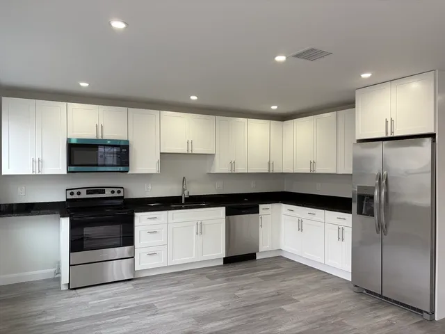 a kitchen with granite countertop a sink and steel stainless steel appliances
