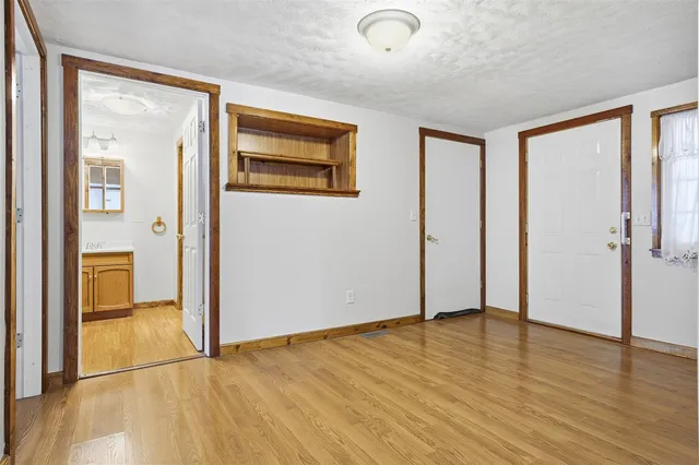 an empty room with wooden floor and a bathroom