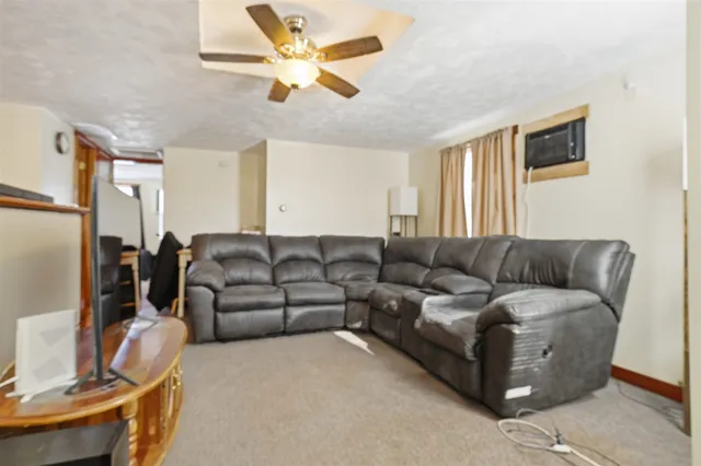 a living room with furniture a refrigerator and a window