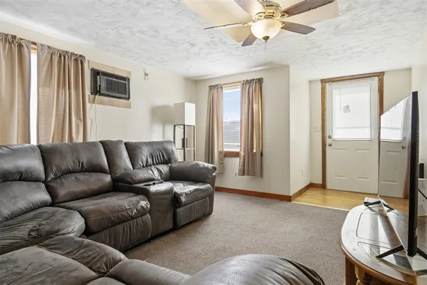 a living room with furniture ceiling fan and a window