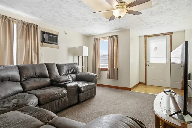 a living room with furniture ceiling fan and a window