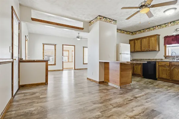 a view of a kitchen with a sink wooden cabinet and a refrigerator