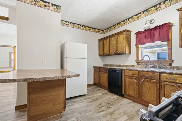 a kitchen with granite countertop a sink cabinets and wooden floor