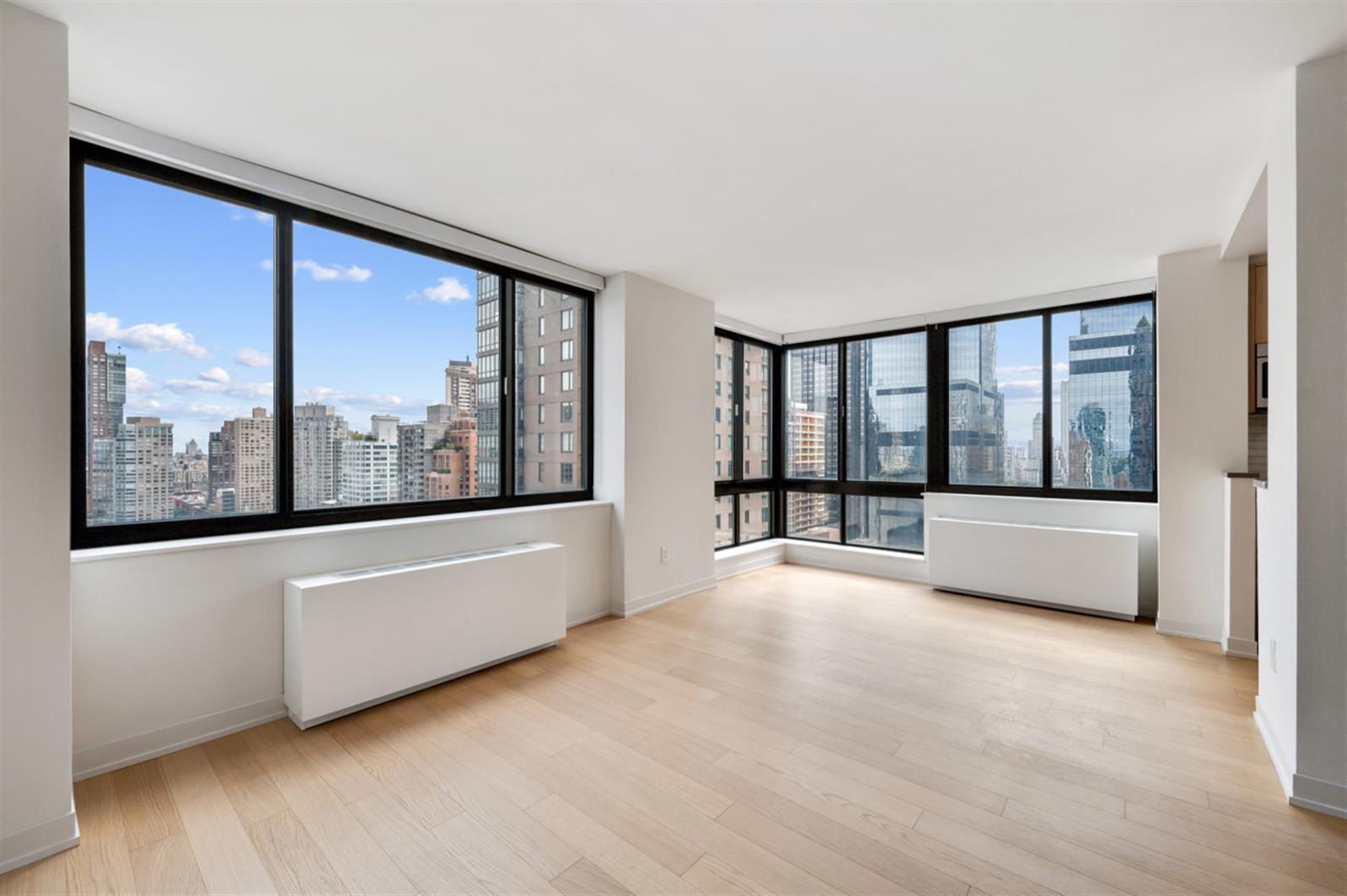 1 Columbus Place, Unit N31B Manhattan, NY 10019 - Photo 8 of 8 a view of an empty room with wooden floor and a window