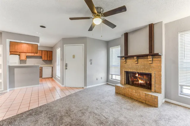 a living room with stainless steel appliances furniture fireplace and flat screen tv