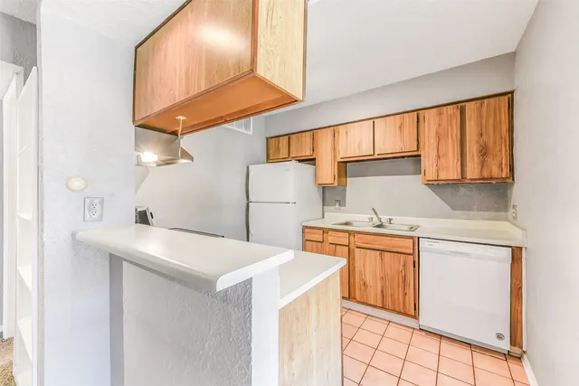 a kitchen with a sink a stove cabinets and a refrigerator