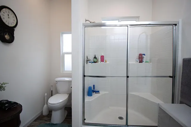 a bathroom with a shower a toilet and a shower
