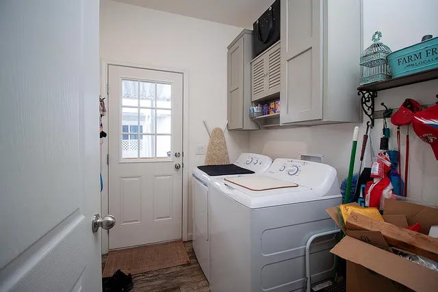 a utility room with dryer washer and a view of living room