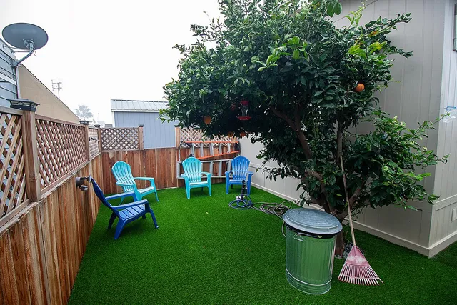a view of a chair and table in backyard of the house