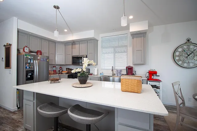 a kitchen with a dining table cabinets and stainless steel appliances