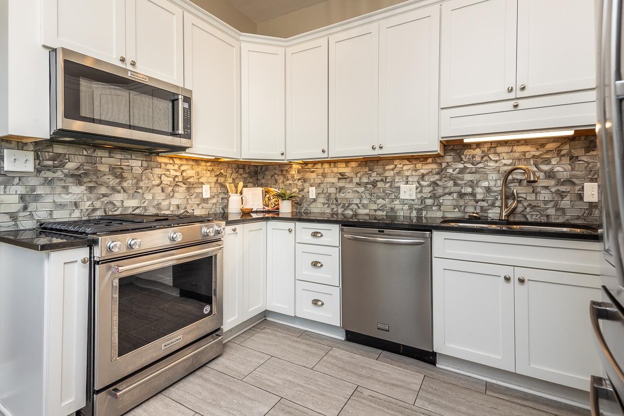 519 Summitt Street Memphis, TN 38104 - Photo 15 of 40 a kitchen with granite countertop white cabinets stainless steel appliances and a sink