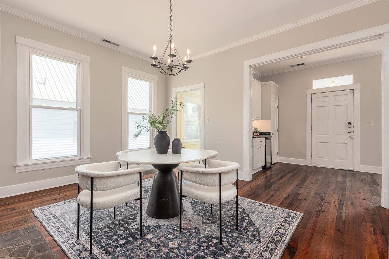 519 Summitt Street Memphis, TN 38104 - Photo 8 of 40 a dining room with wooden floor a chandelier a wooden table and chairs