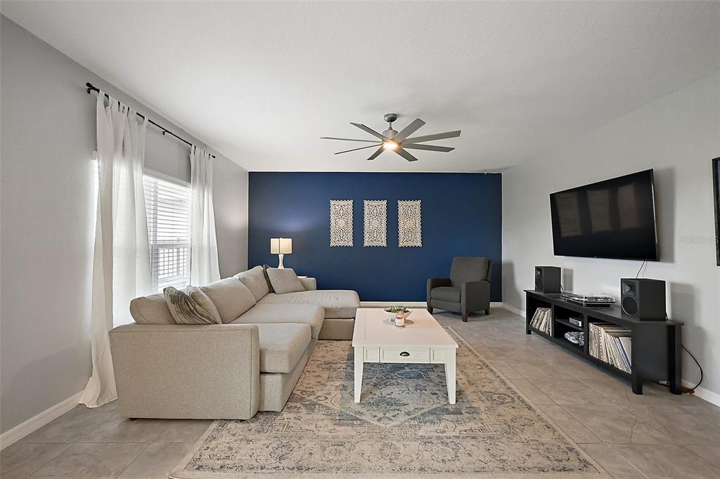 1292 Cavender Creek Road Minneola, FL 34715 - Photo 16 of 36 a living room with furniture and a flat screen tv