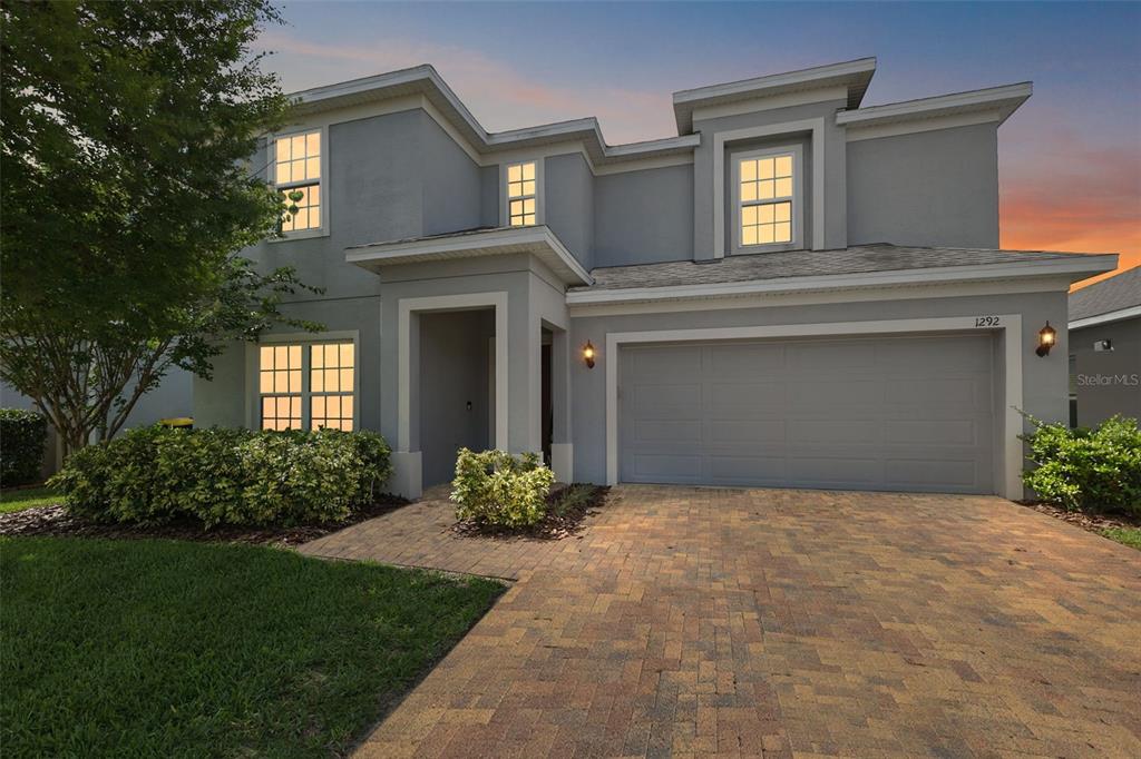 1292 Cavender Creek Road Minneola, FL 34715 - Photo 2 of 36 a front view of a house with garden