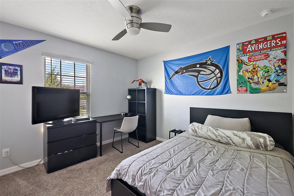 1292 Cavender Creek Road Minneola, FL 34715 - Photo 22 of 36 a bedroom with a bed and a flat screen tv