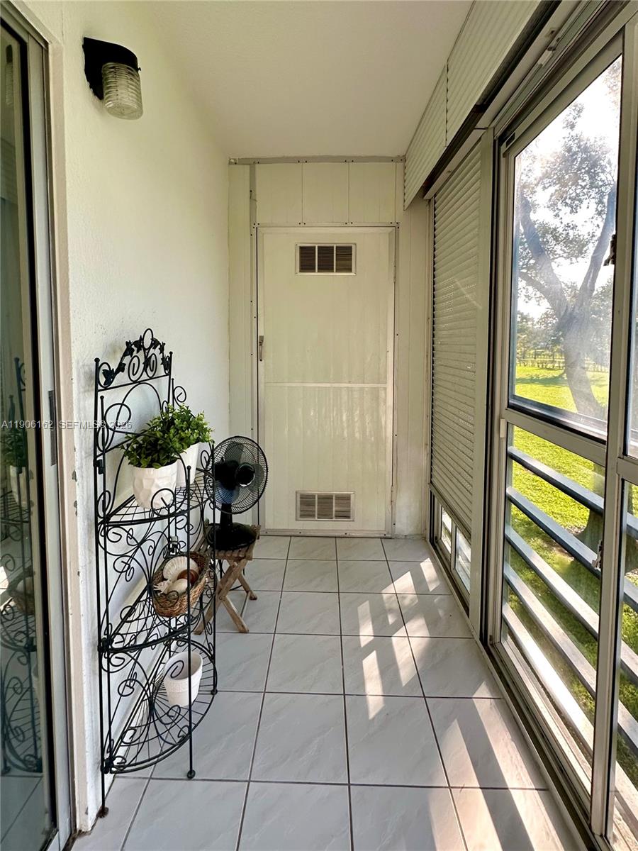 142 Preston F, Unit 142 Boca Raton, FL 33434 - Photo 14 of 28 a view of a porch with furniture and floor to ceiling window