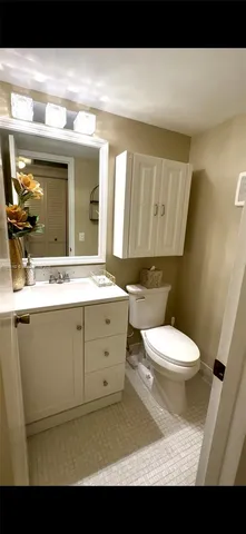 a bathroom with a toilet a sink and mirror