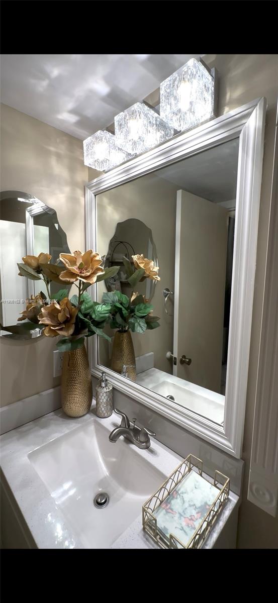 142 Preston F, Unit 142 Boca Raton, FL 33434 - Photo 5 of 23 a bathroom with a sink and a mirror