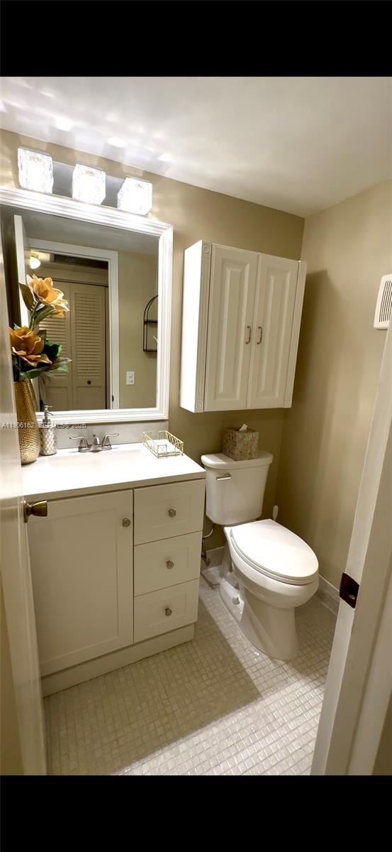 142 Preston F, Unit 142 Boca Raton, FL 33434 - Photo 6 of 28 a bathroom with a toilet a sink and mirror