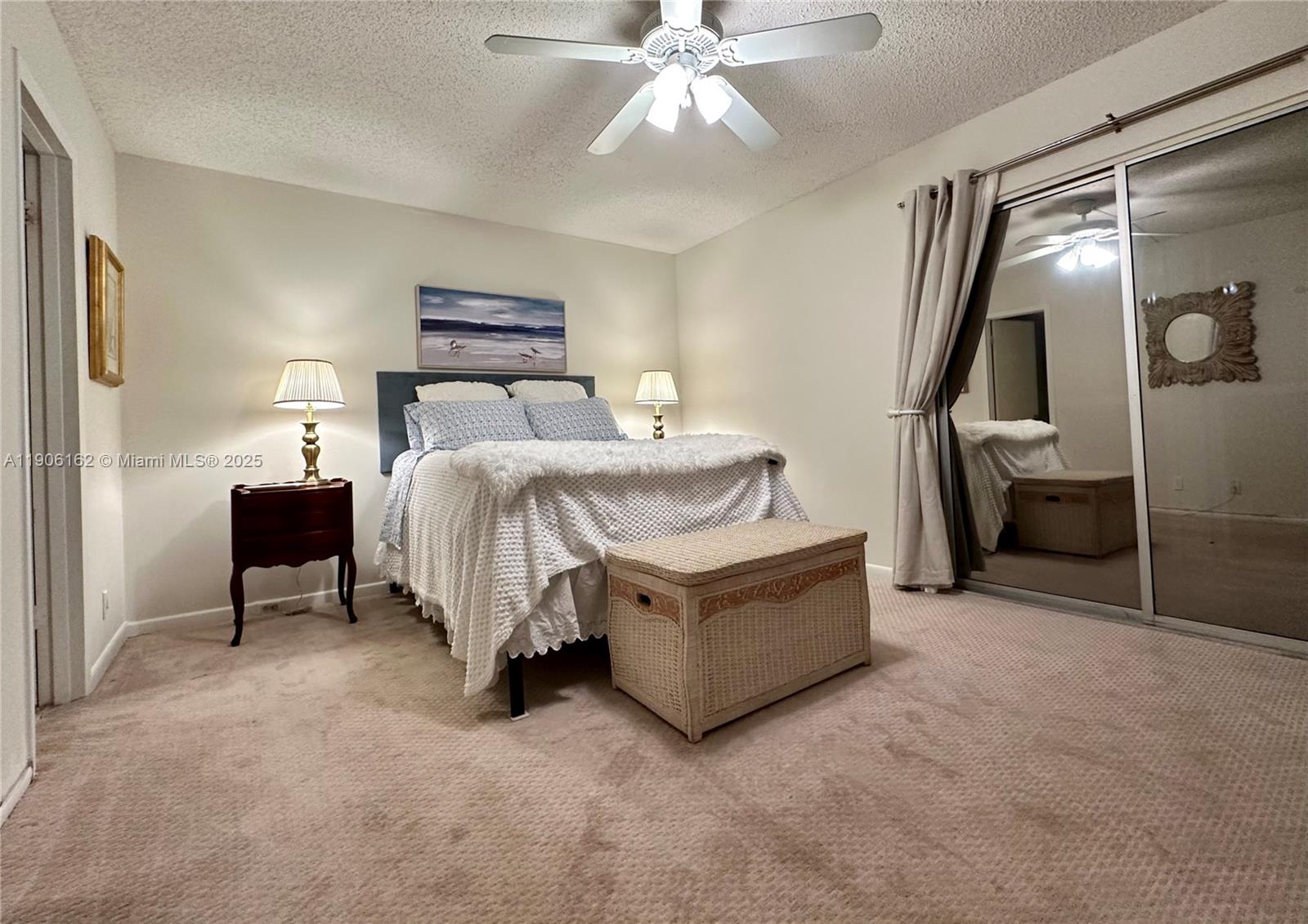 142 Preston F, Unit 142 Boca Raton, FL 33434 - Photo 6 of 23 a spacious bedroom with a bed and a chandelier