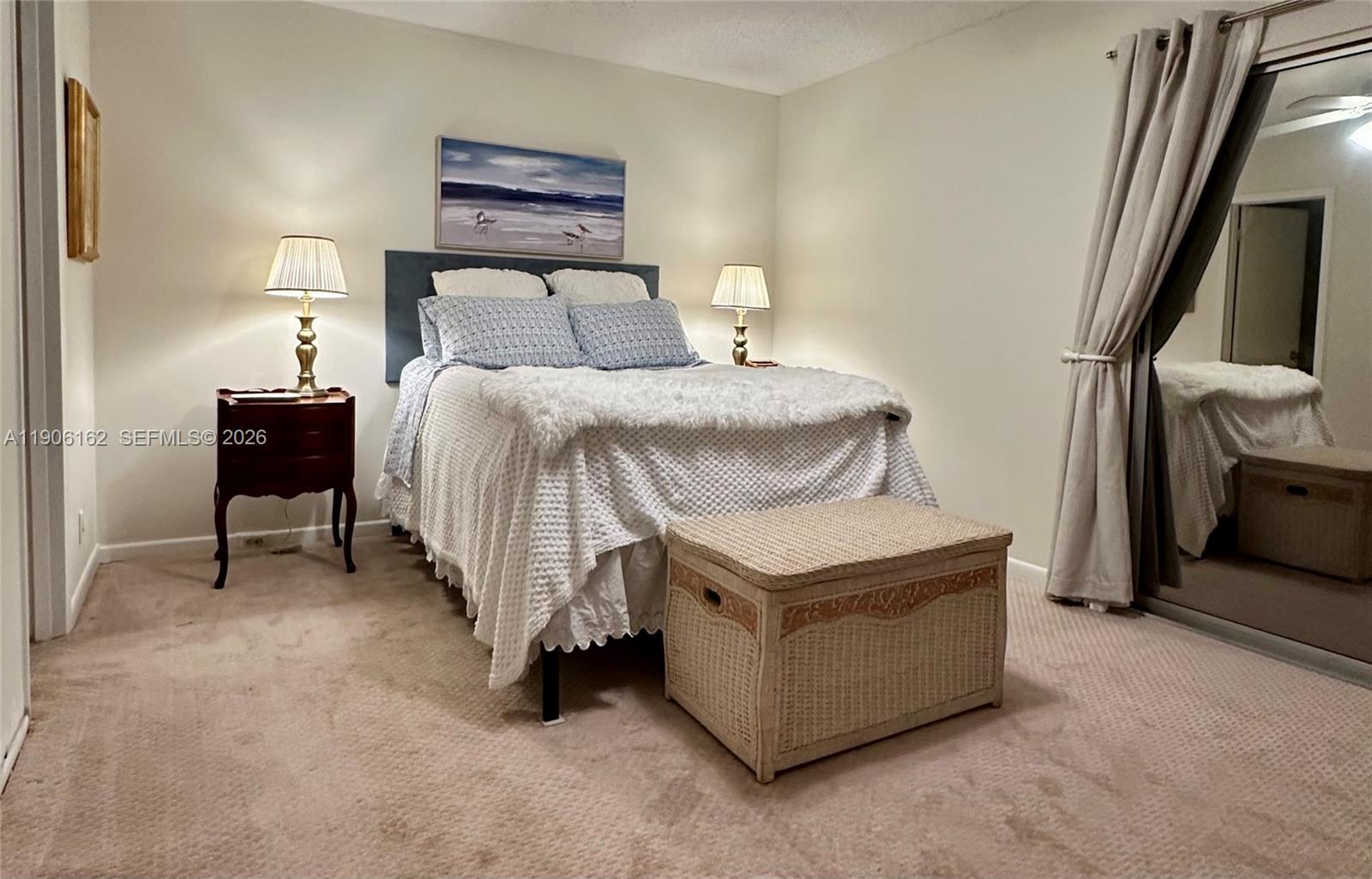 142 Preston F, Unit 142 Boca Raton, FL 33434 - Photo 8 of 28 a bedroom with a bed and a lamp on table