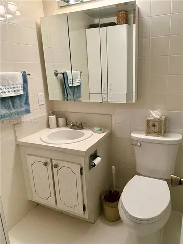 a bathroom with a sink a toilet and mirror